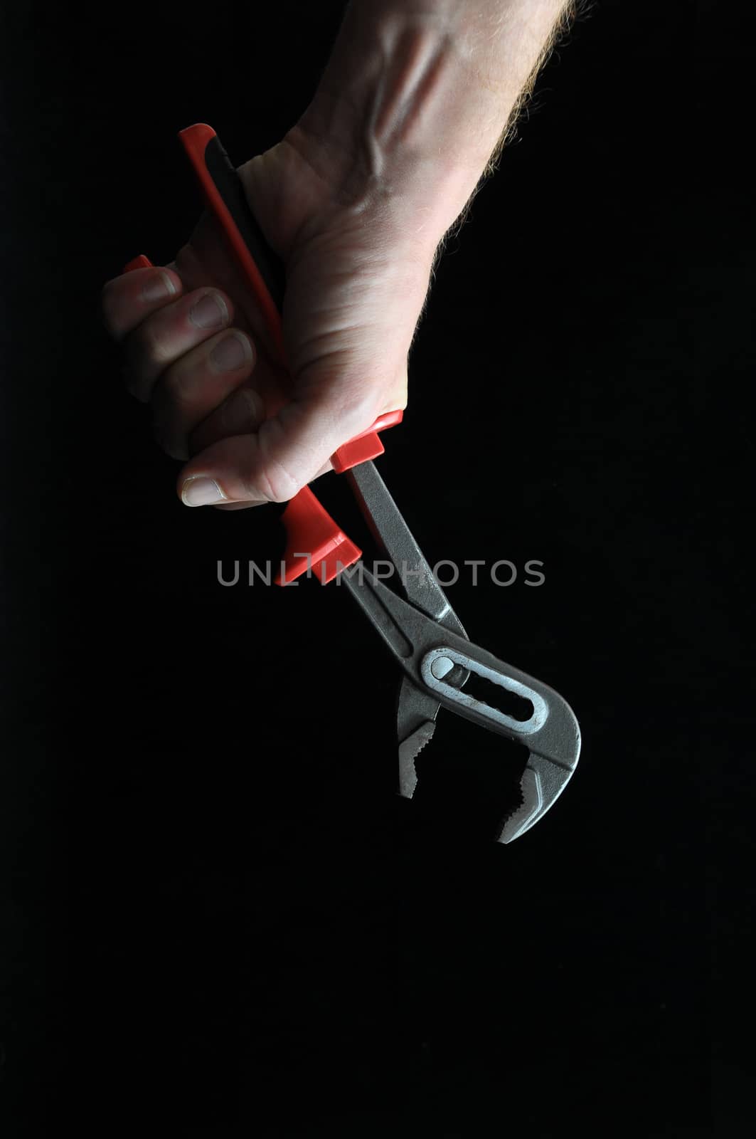 Pliers and a Hand on a Black Background