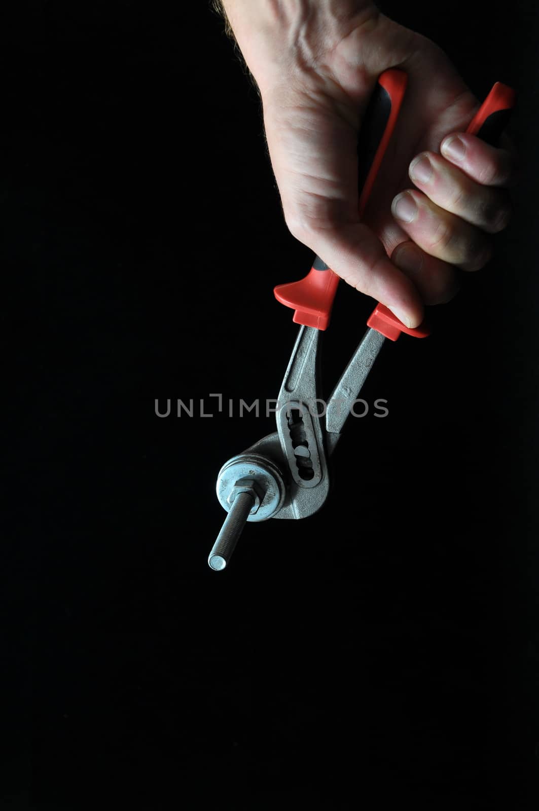Pliers and a Hand on a Black Background
