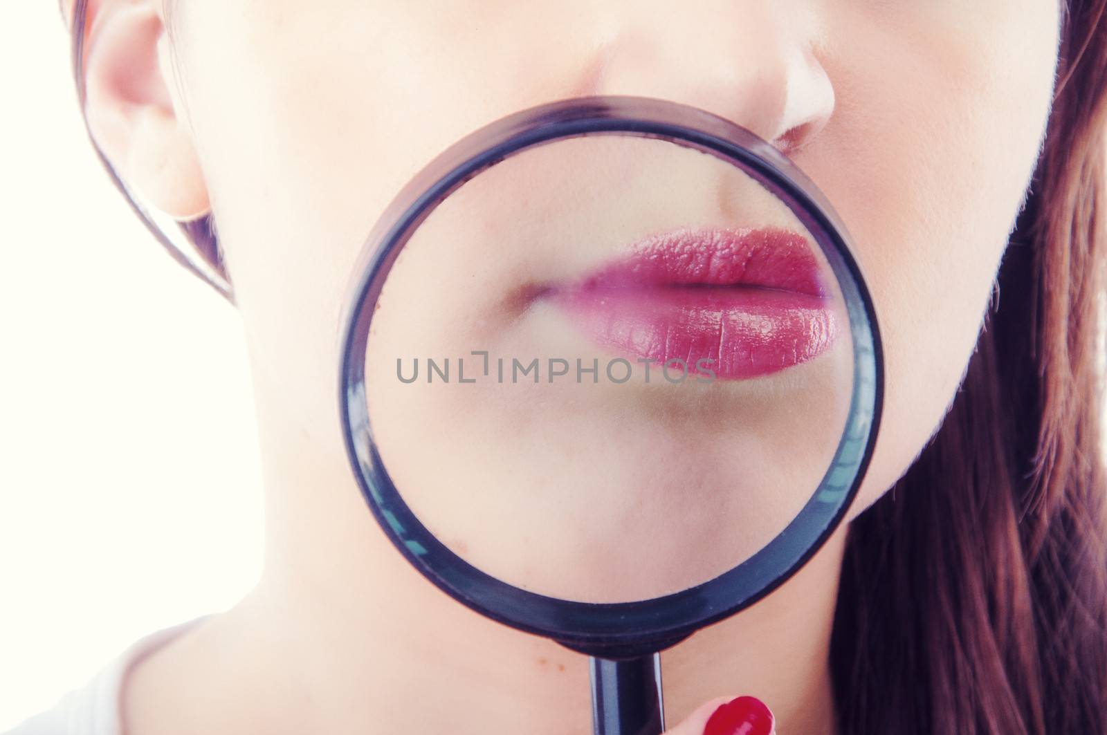 An image of Women with magnifying glass over her lips