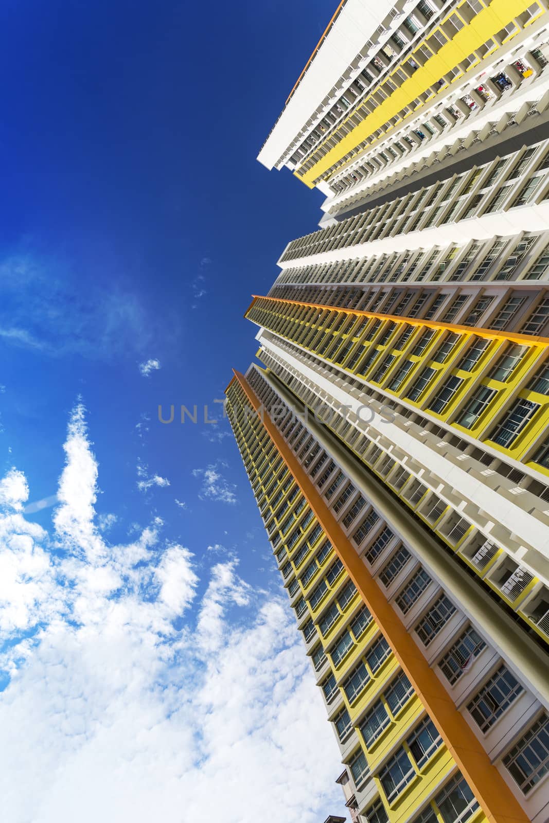 An extreme low angle shot of a new colorful high rise apartment against the sky.