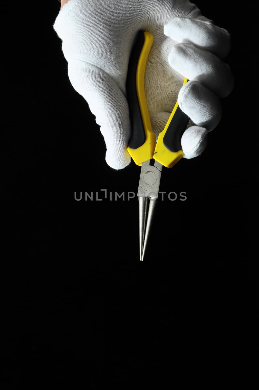 Pliers and a Hand on a Black Background