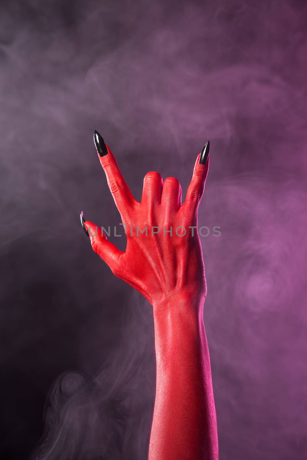 Heavy metal gesture, red devil hand with black nails, Halloween 