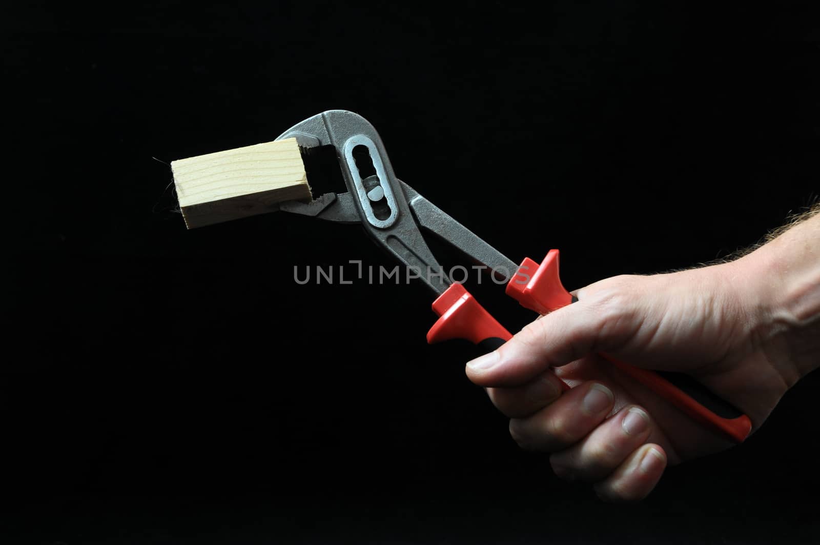 Pliers and a Hand on a Black Background