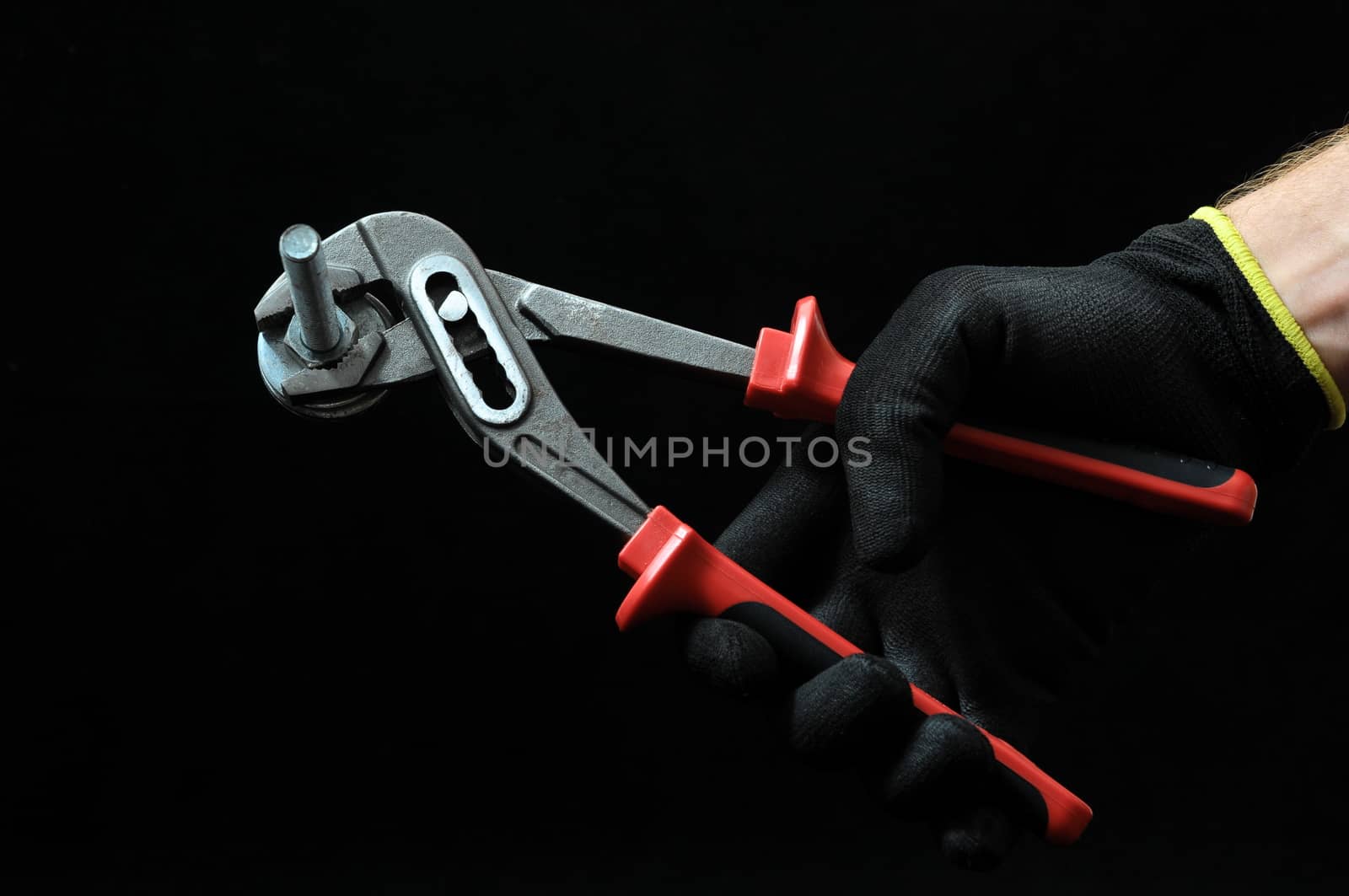 Pliers and a Hand on a Black Background