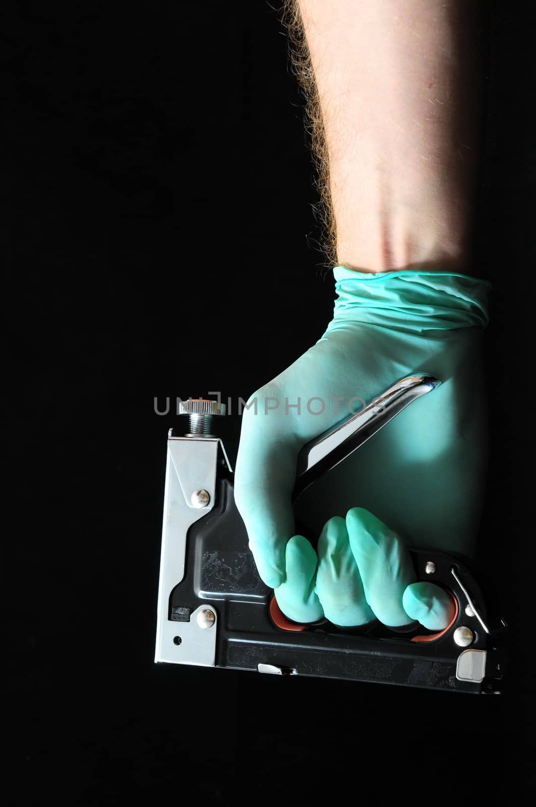 Stapler Pliers and a Hand on a Black Background