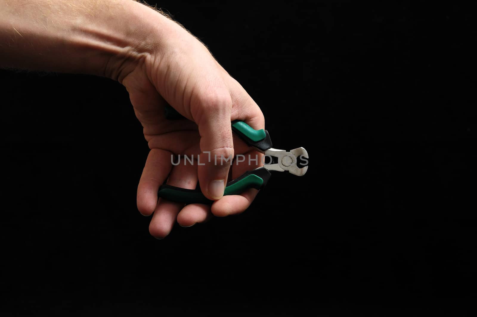 Cutter Pliers and a Hand on a Black Background