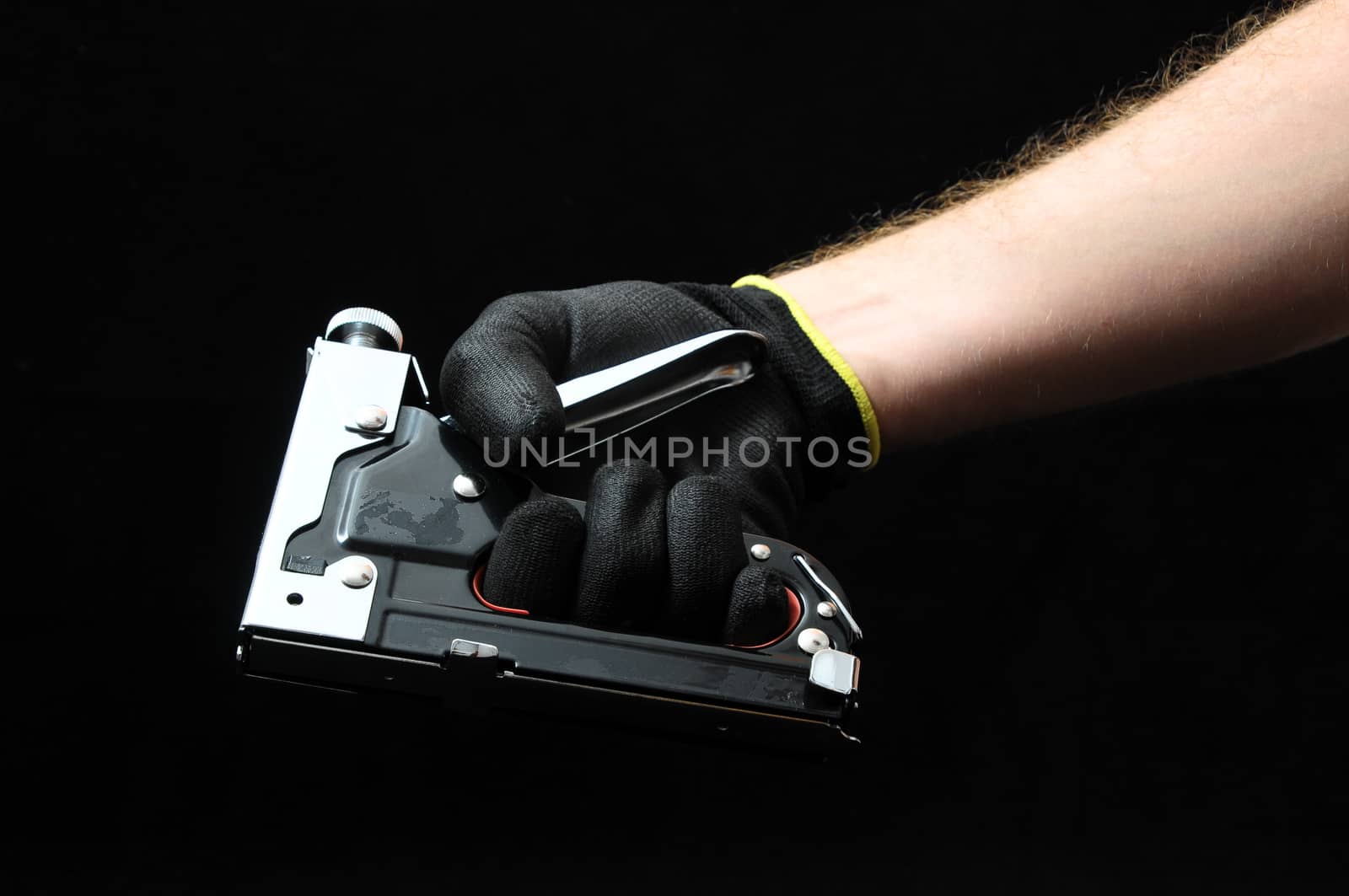 Stapler Pliers and a Hand on a Black Background