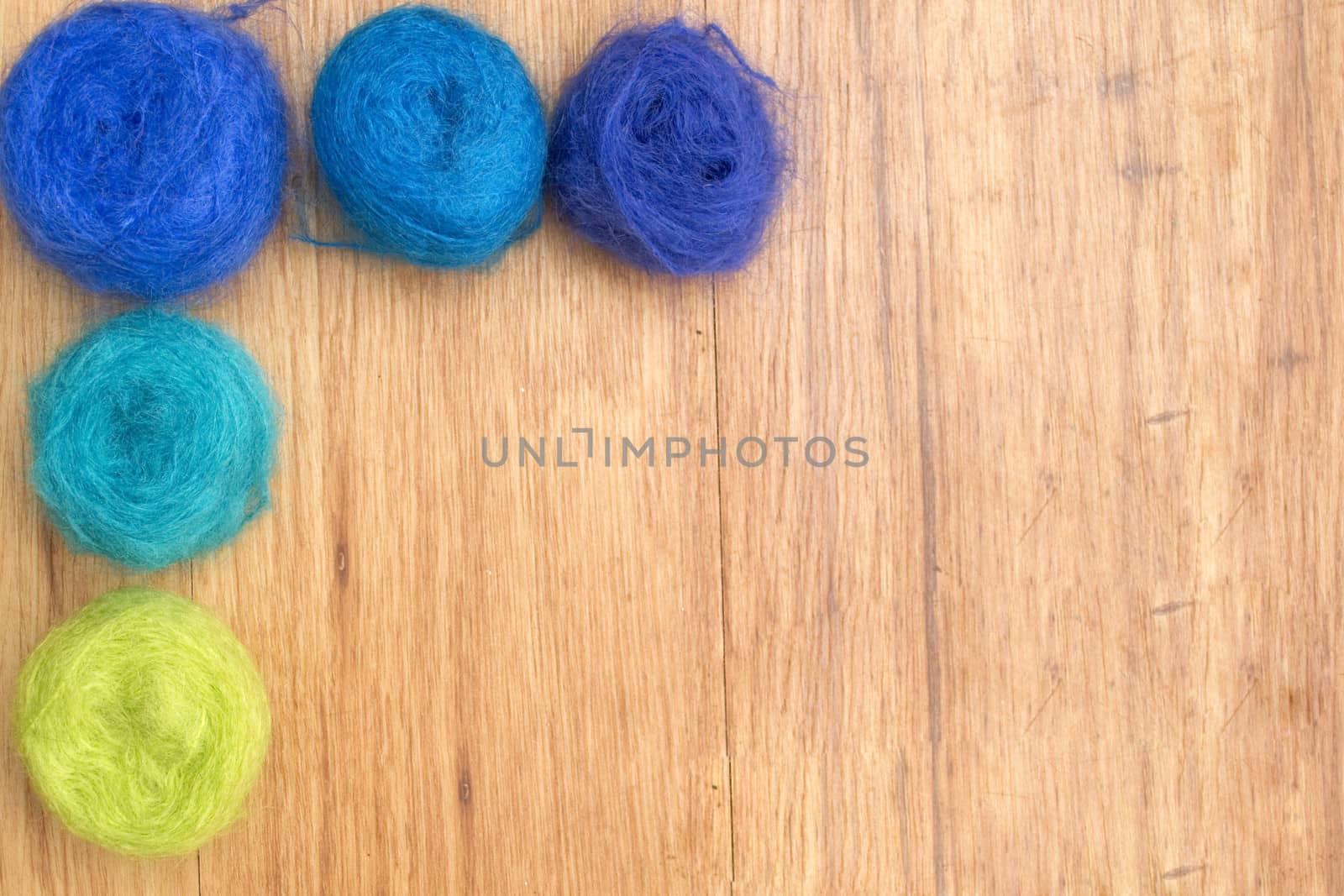 Three balls of blue yarn on a white background