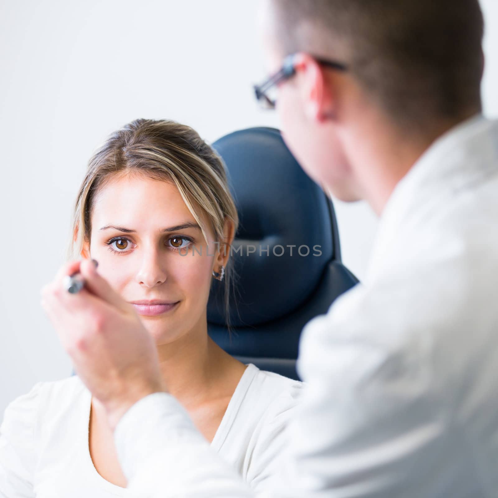 optometry concept - pretty young woman having her eyes examined  by viktor_cap