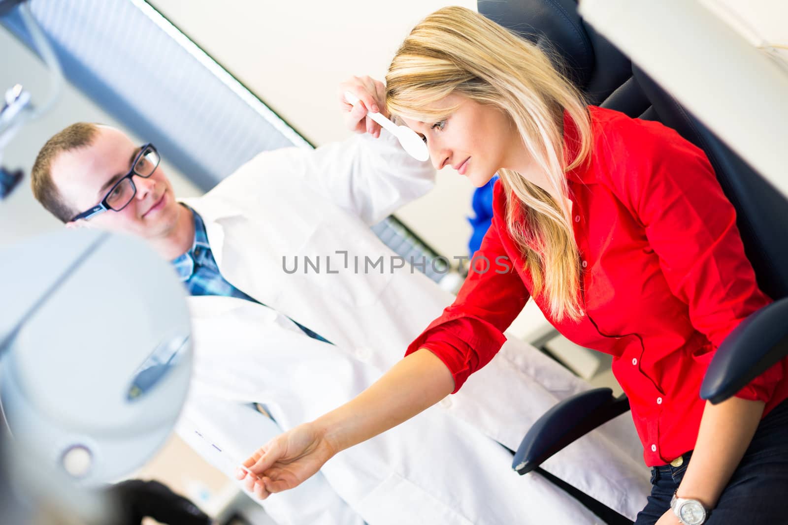 Optometry concept - pretty young woman having her eyes examined by an eye doctor (color toned image; shallow DOF)