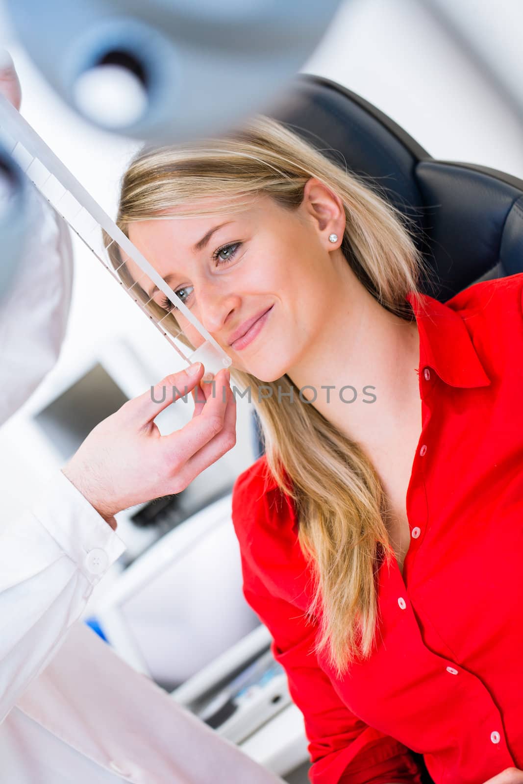 Optometry concept - pretty young woman having her eyes examined by an eye doctor (color toned image; shallow DOF)