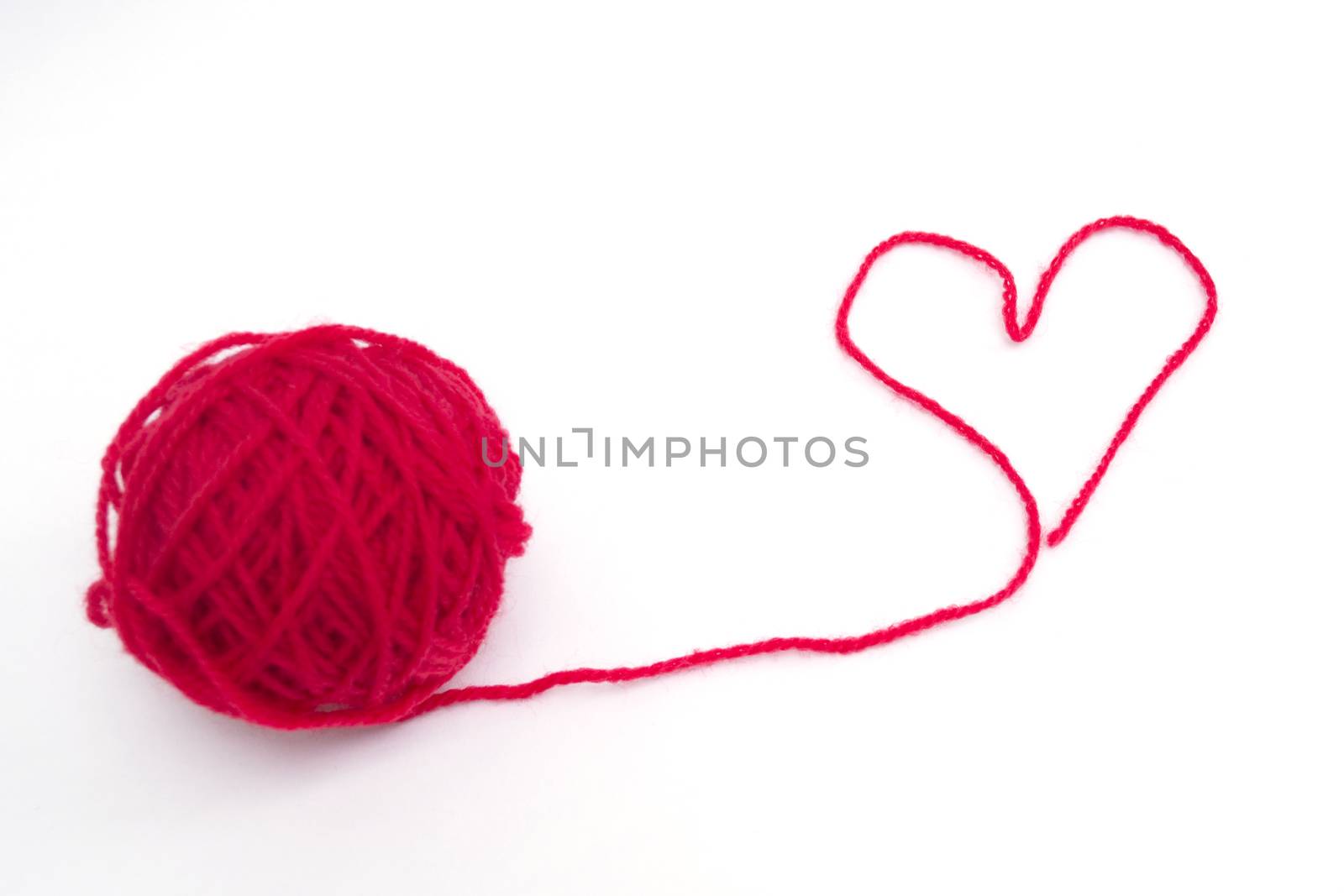 Red ball of wool creating a heart shape