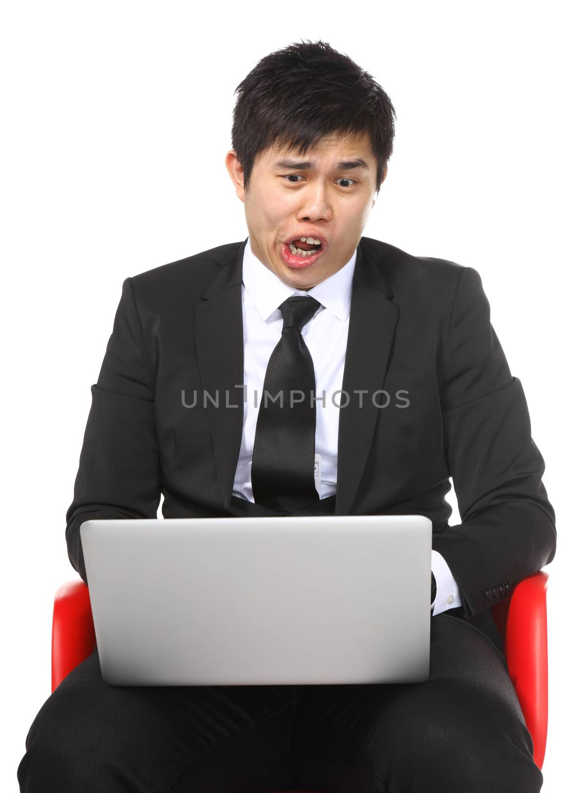 Asian businessman shocked surprise by laptop computer by leungchopan