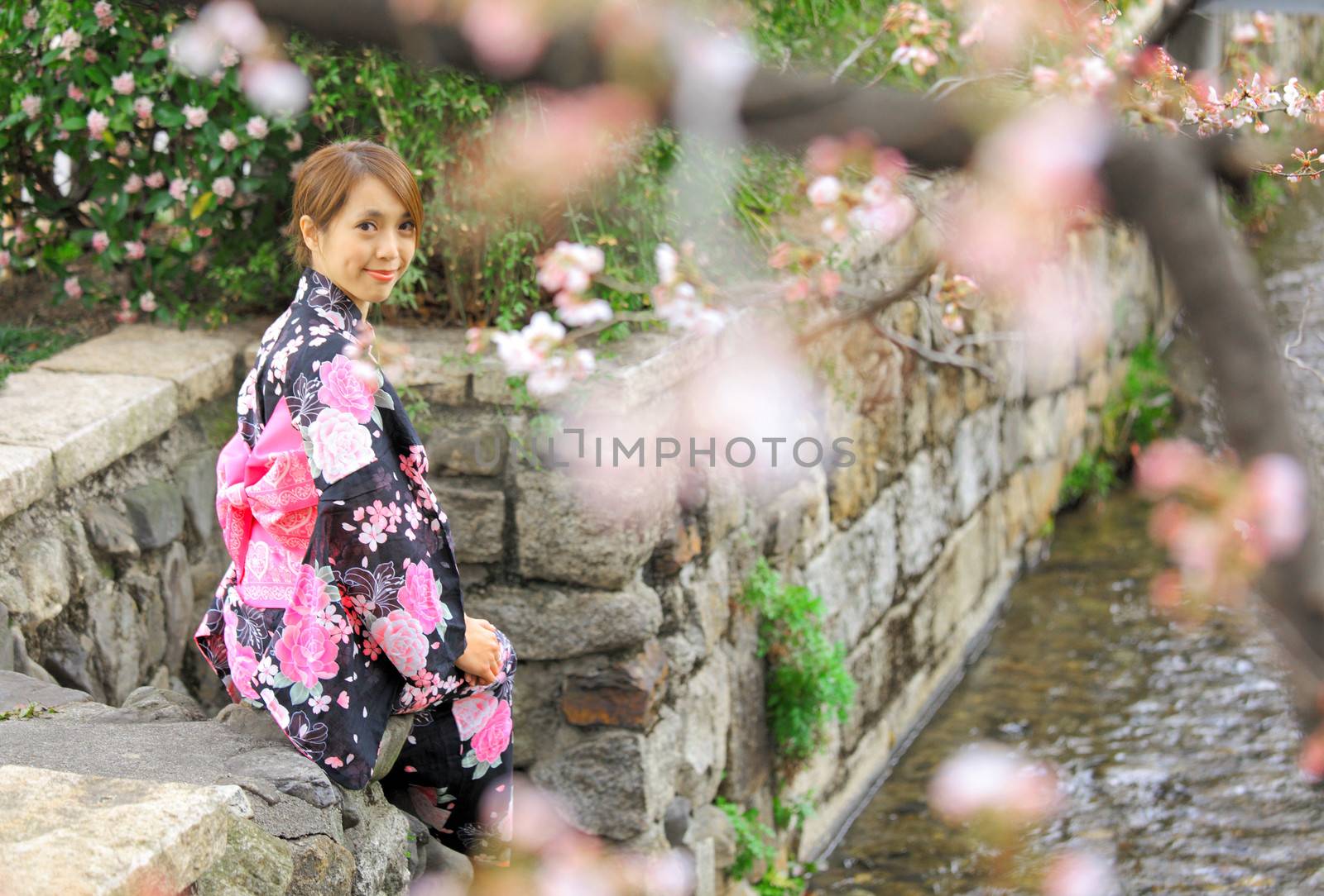 Young woman wearing Japanese kimono with cherry blossom by leungchopan