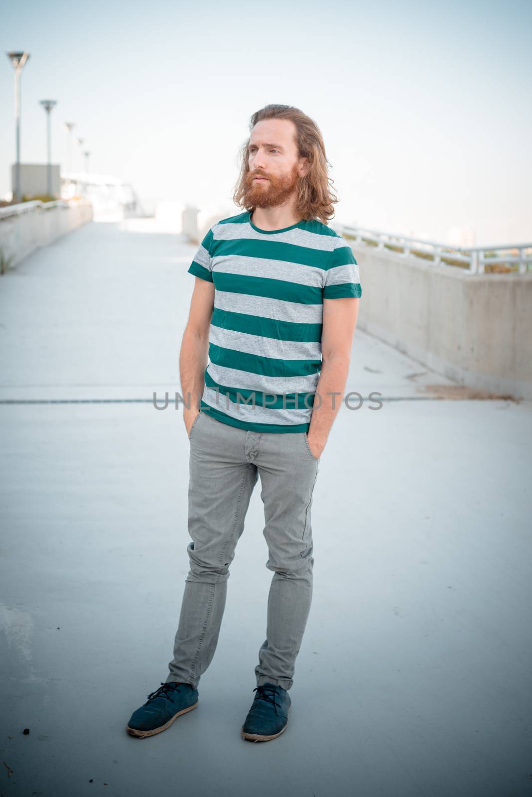 stylish hipster model with long red hair and beard lifestyle in the street
