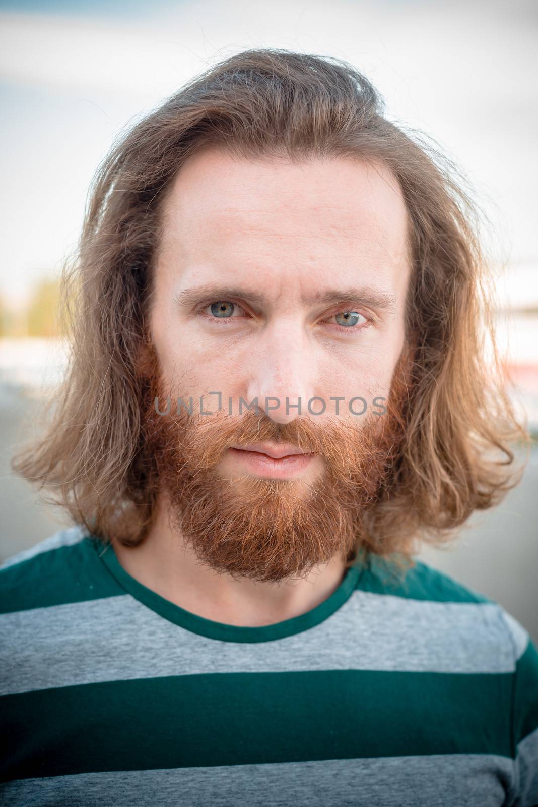 stylish hipster model with long red hair and beard lifestyle in the street