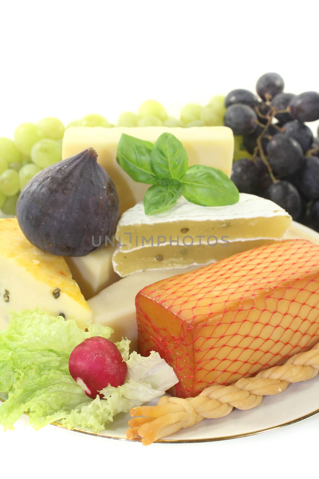 Pieces of cheese with fig, grapes, bread and lettuce