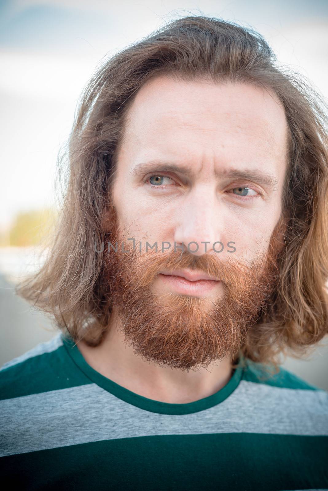 stylish hipster model with long red hair and beard lifestyle in the street