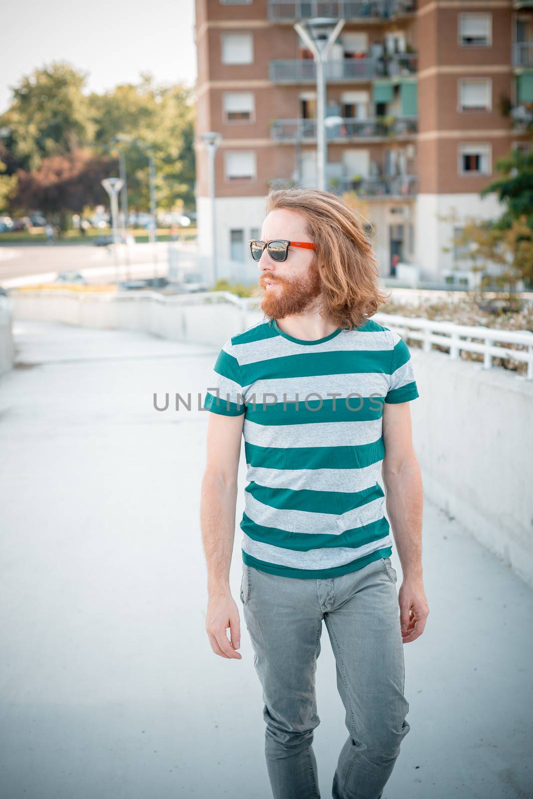 stylish hipster model with long red hair and beard lifestyle in the street