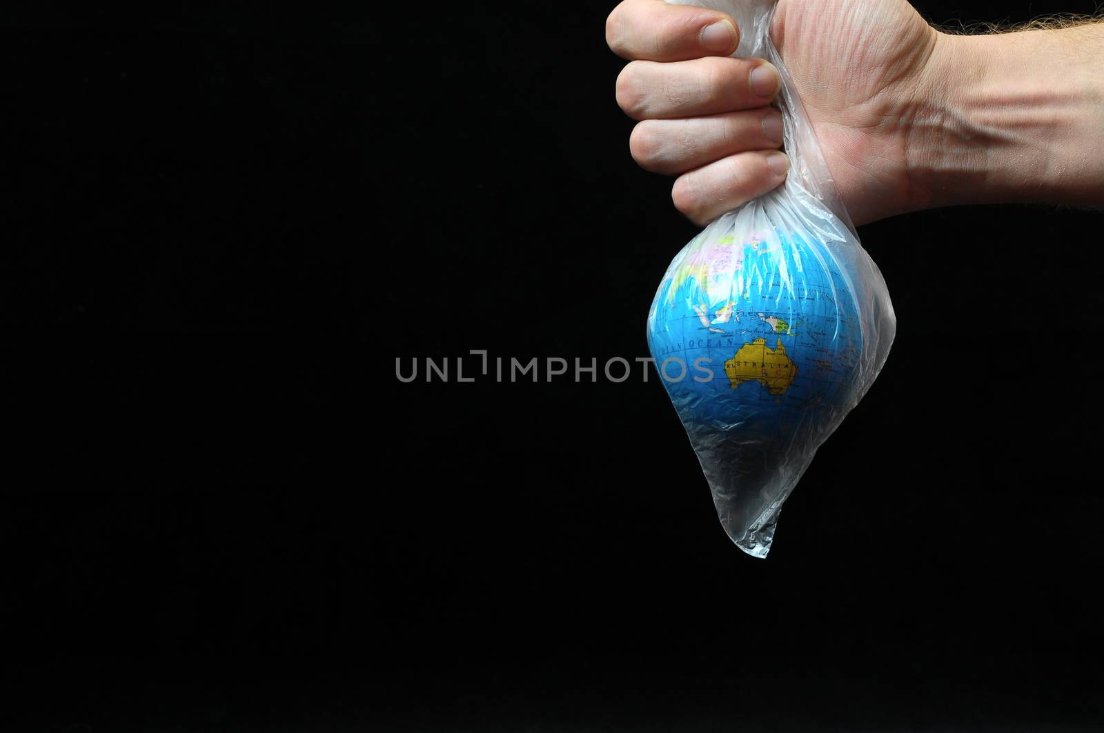 Trapped Planet Earth and an Hand on a Black Background