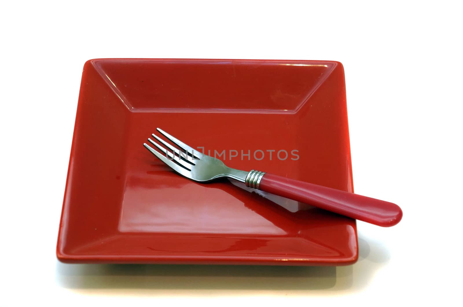 Red dessert plate and fork isolated on white