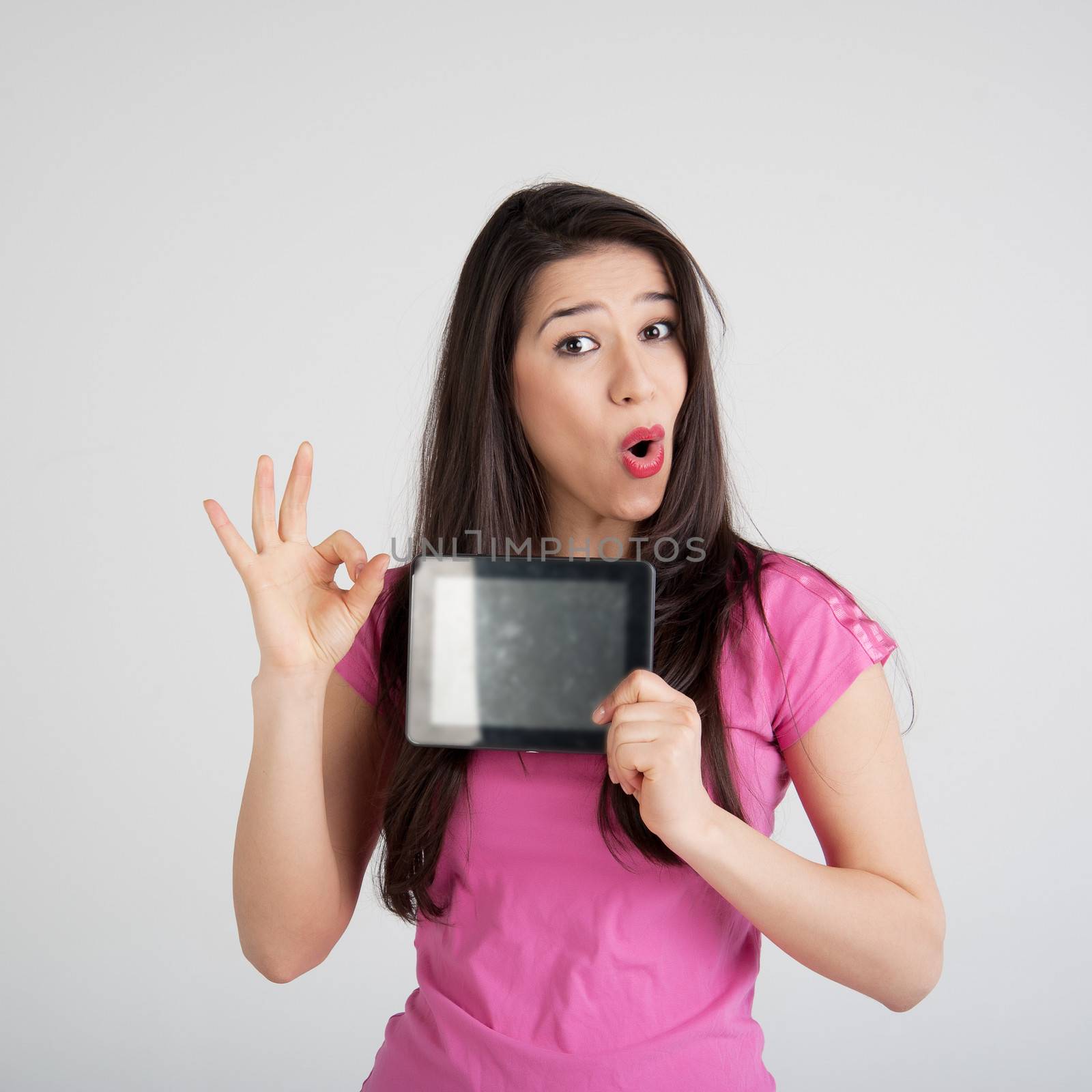 beautiful woman in pink t-shirt is pleased tablet