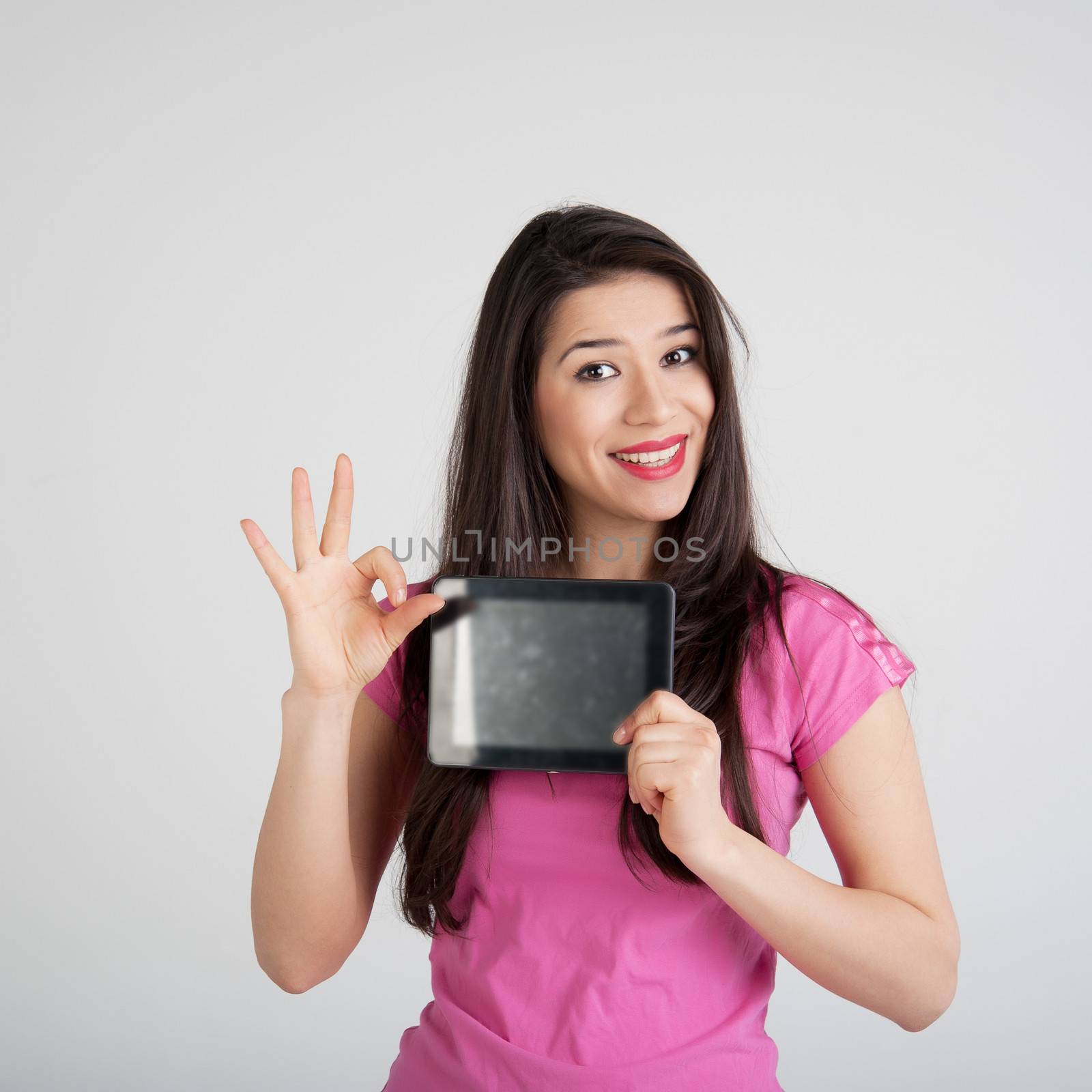 beautiful woman in pink t-shirt is pleased tablet
