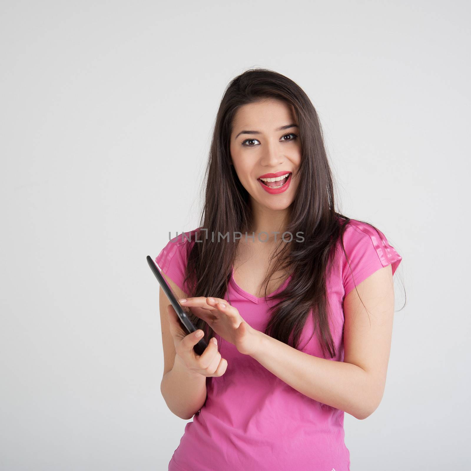 beautiful woman in pink t-shirt is pleased tablet