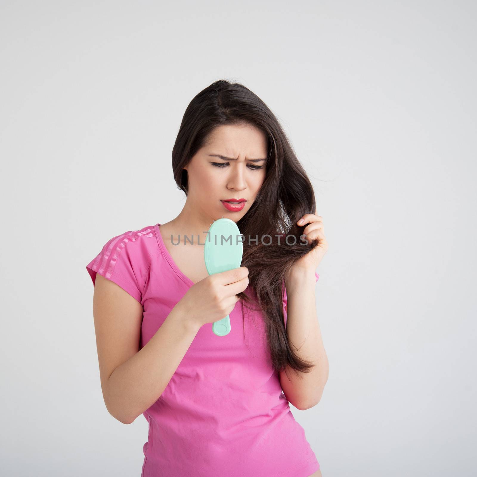 shocked woman losing hair on hairbrush