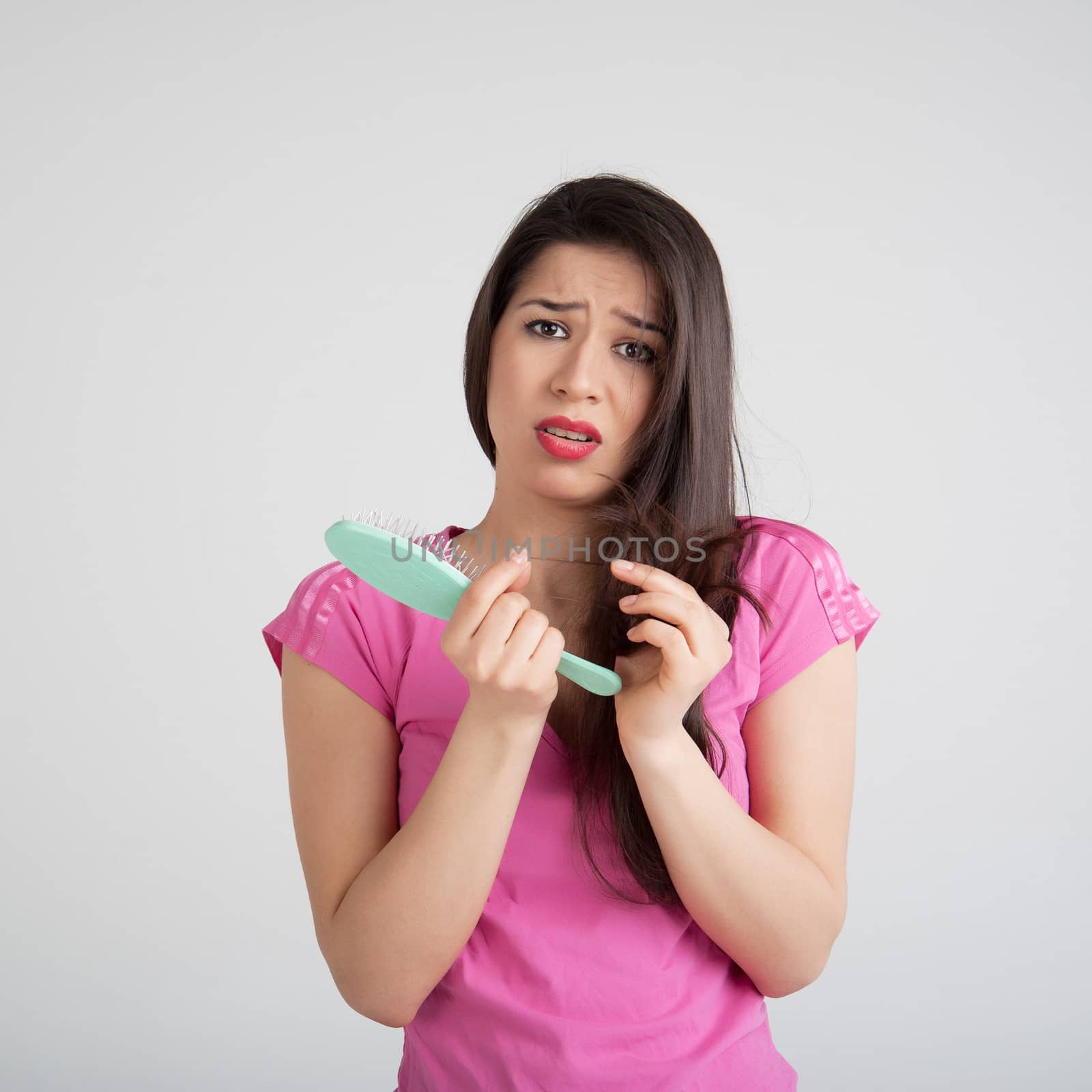 shocked woman losing hair on hairbrush