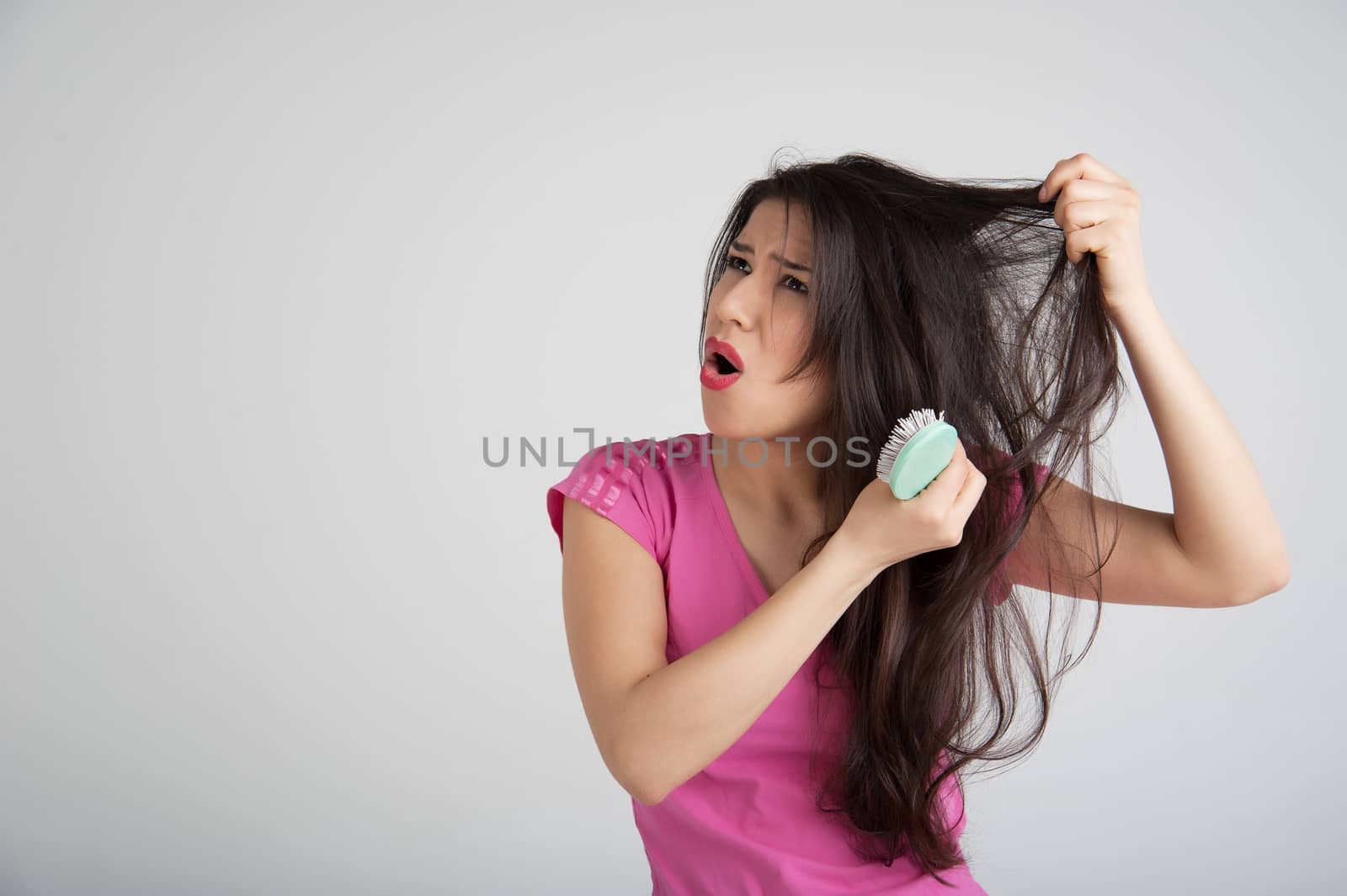 shocked woman losing hair on hairbrush