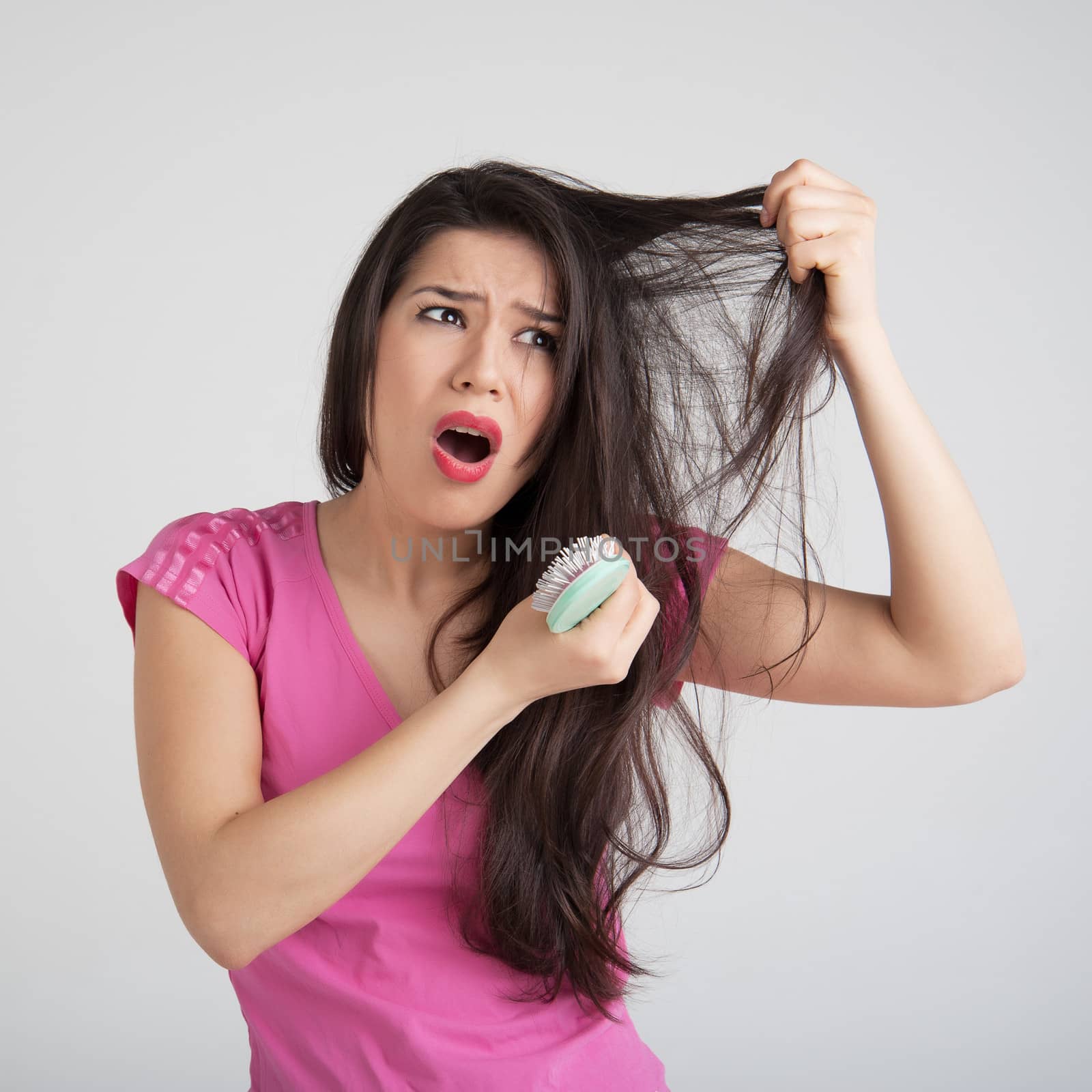 shocked woman losing hair on hairbrush