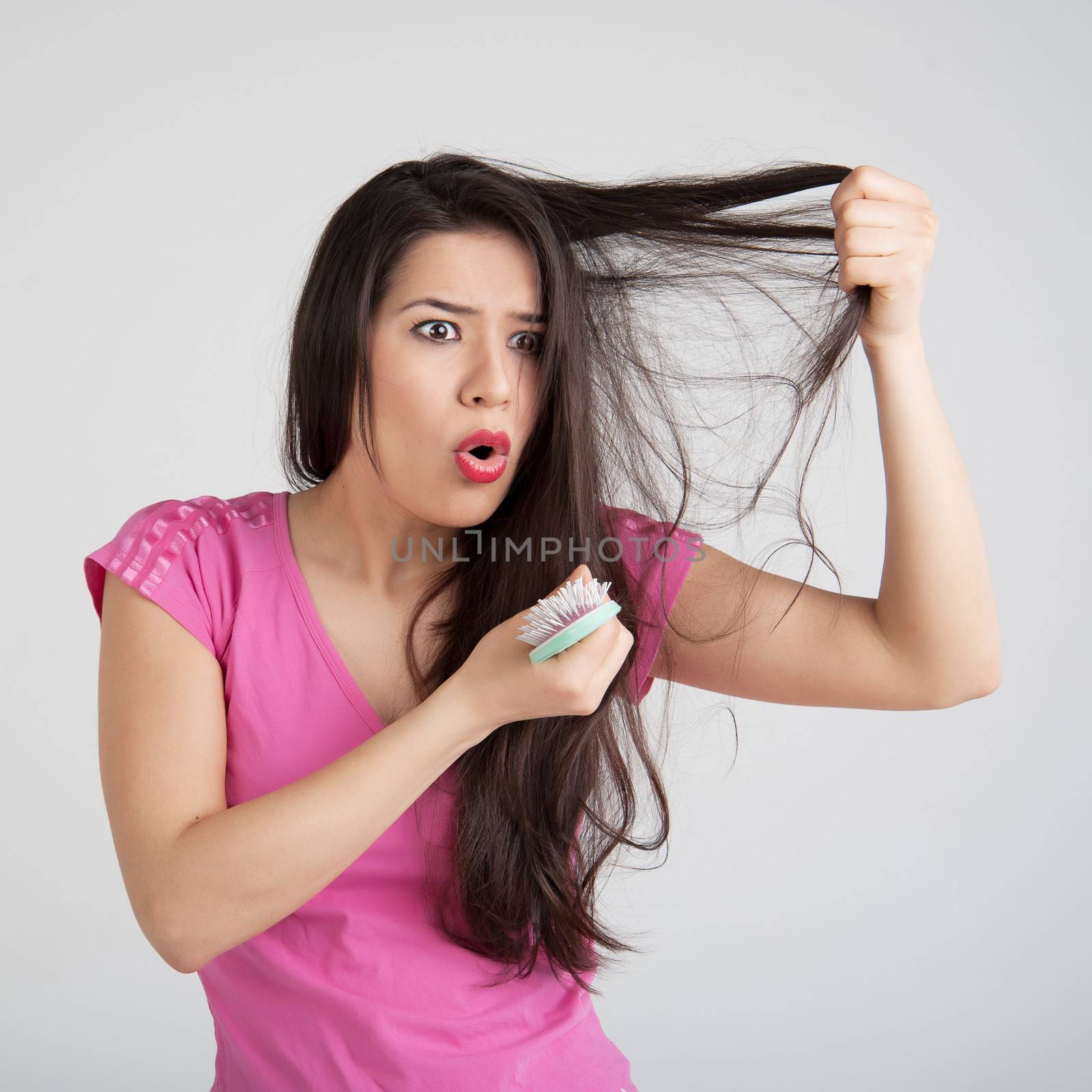 shocked woman losing hair on hairbrush