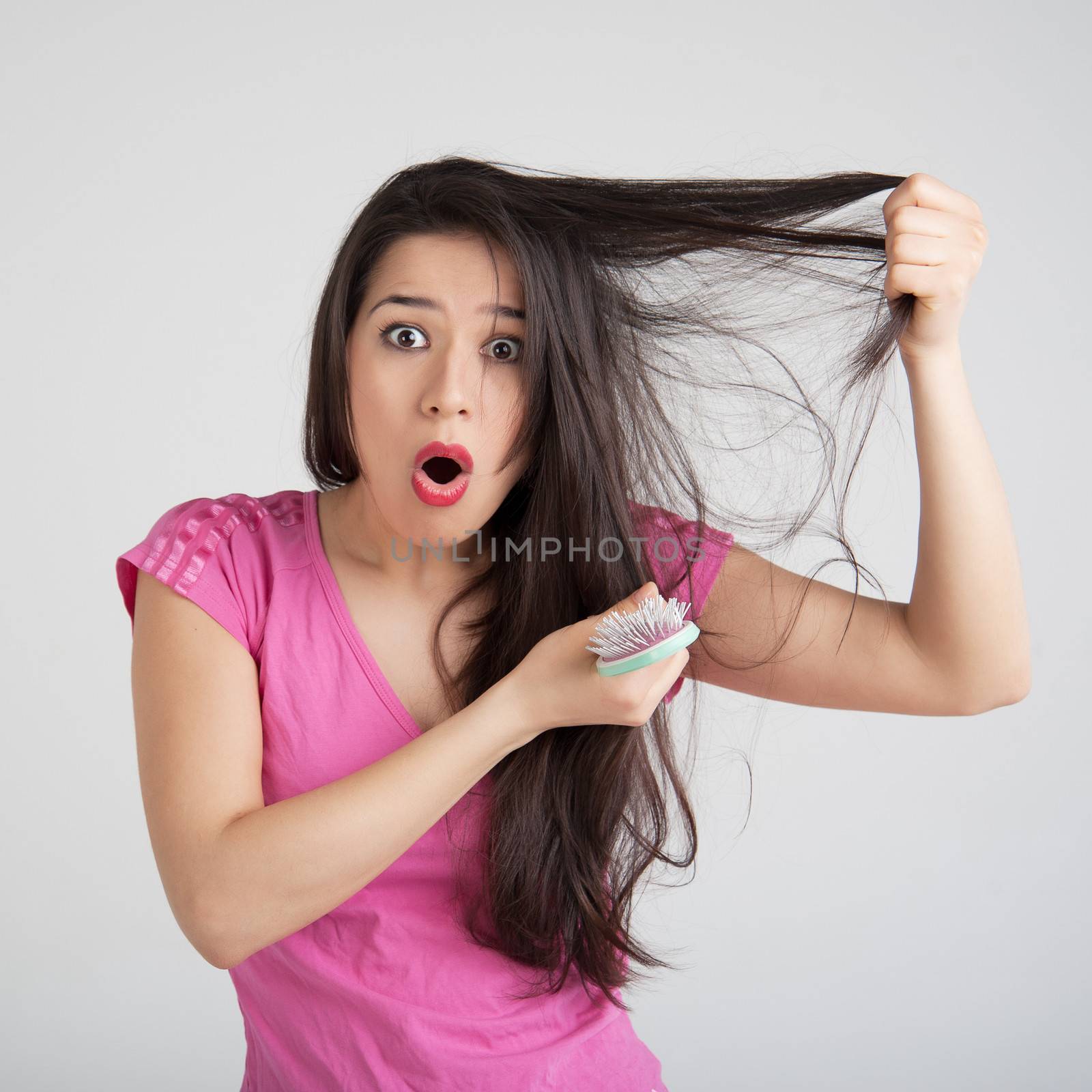 shocked woman losing hair on hairbrush