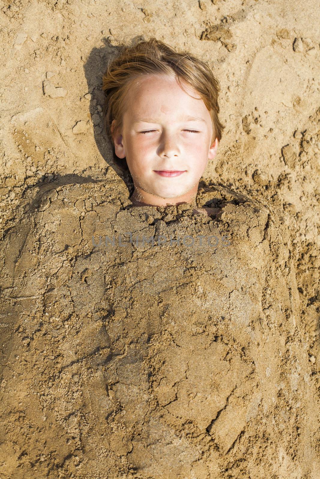 happy boy dig oneself in the sand by anelina
