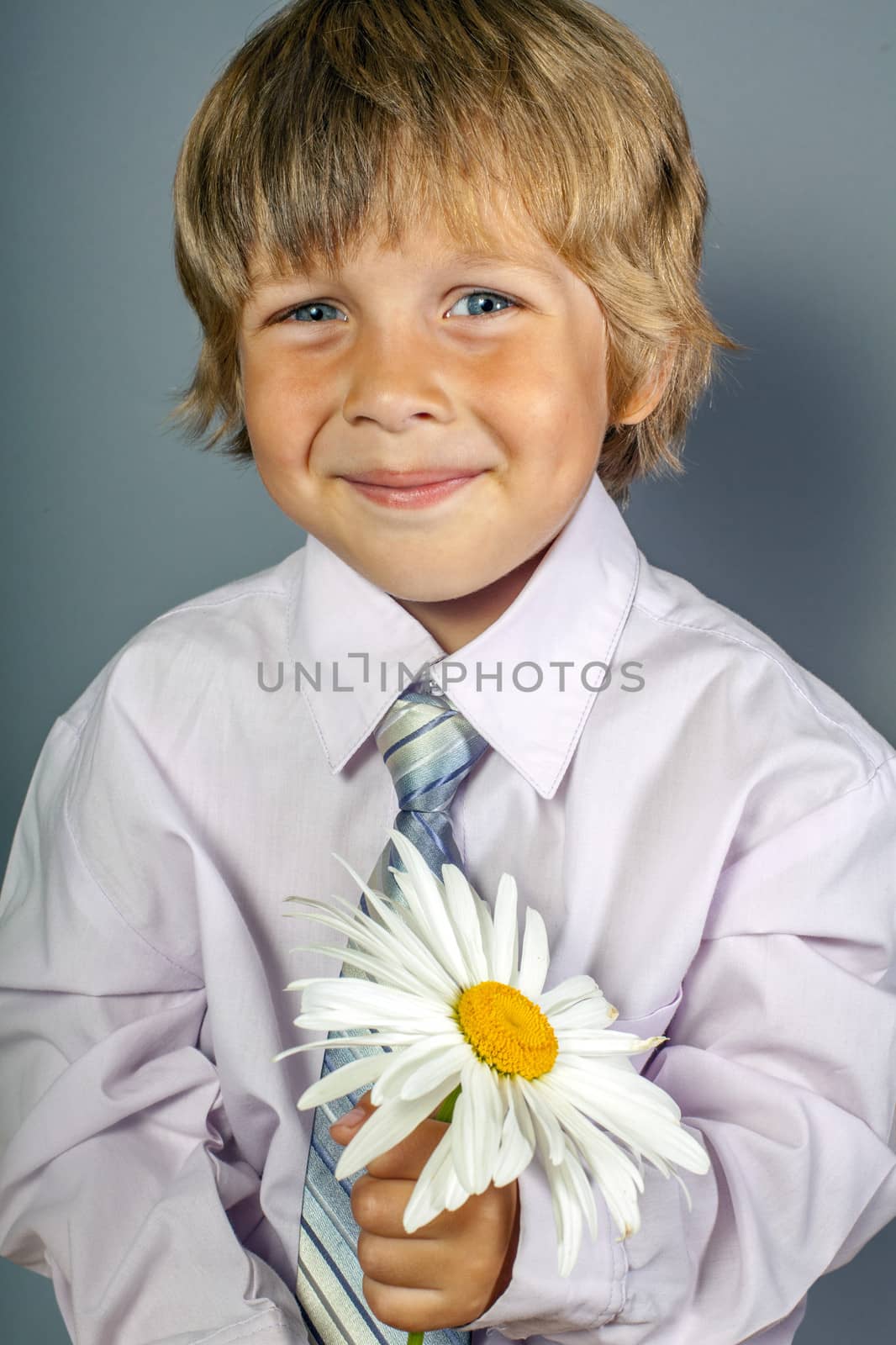 handsome boy wearing classic suit with flowers in hands