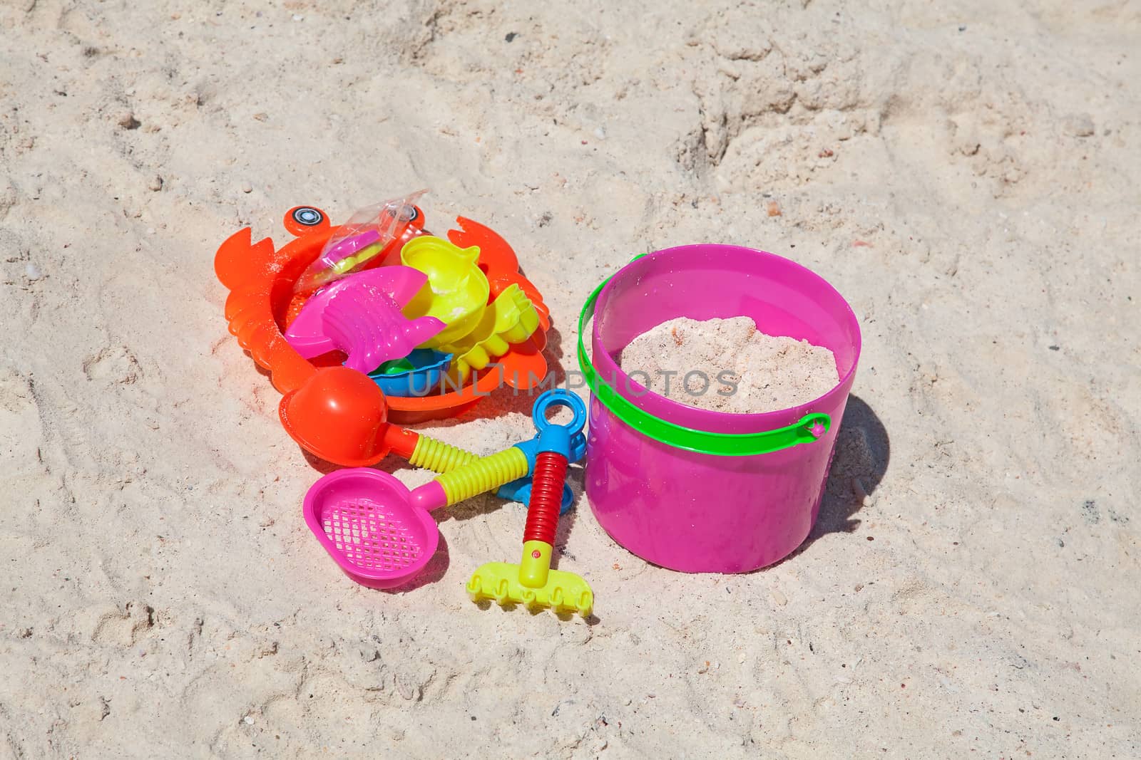 Bright plastic toys on a sandy beach
