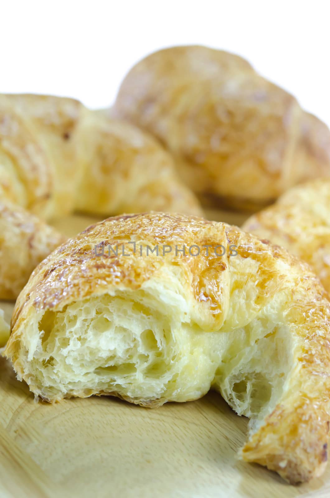close up croissants on wooden plate ,  on white background , fresh bread