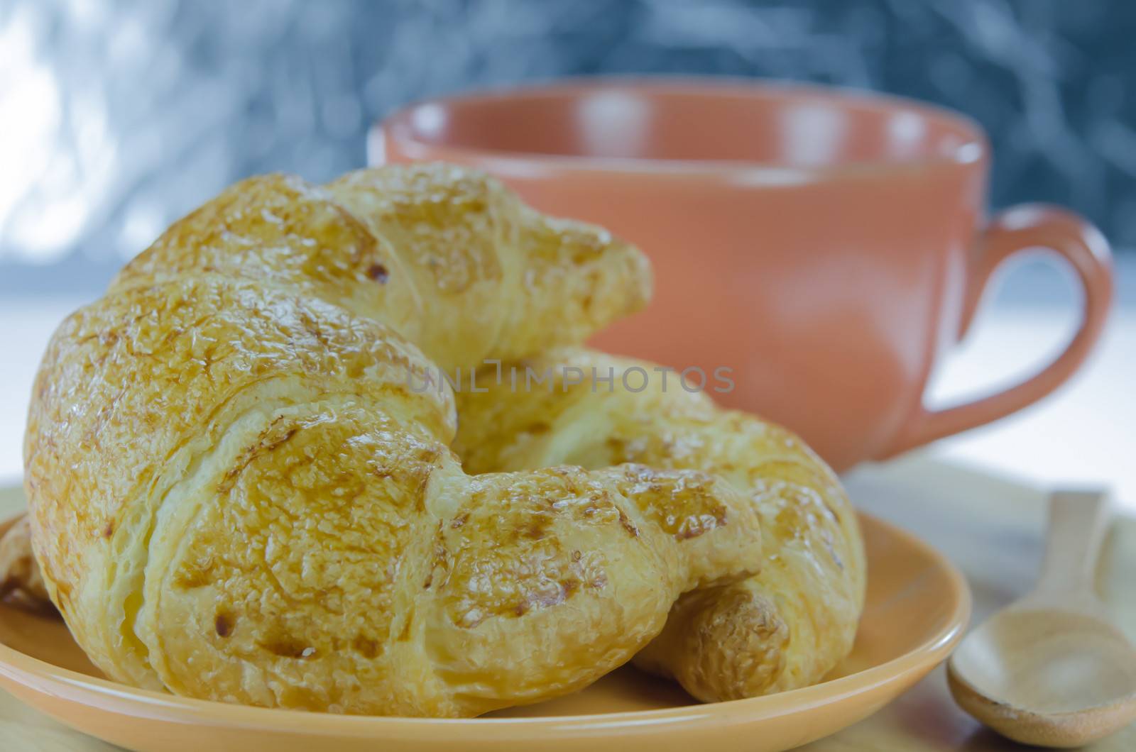 close up  croissants on  brown dish  and a cup of coffee