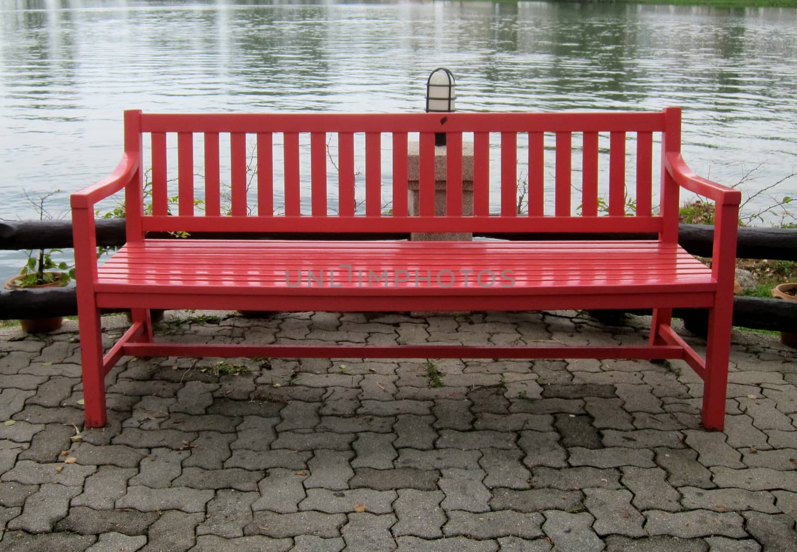 Red park bench by a lake