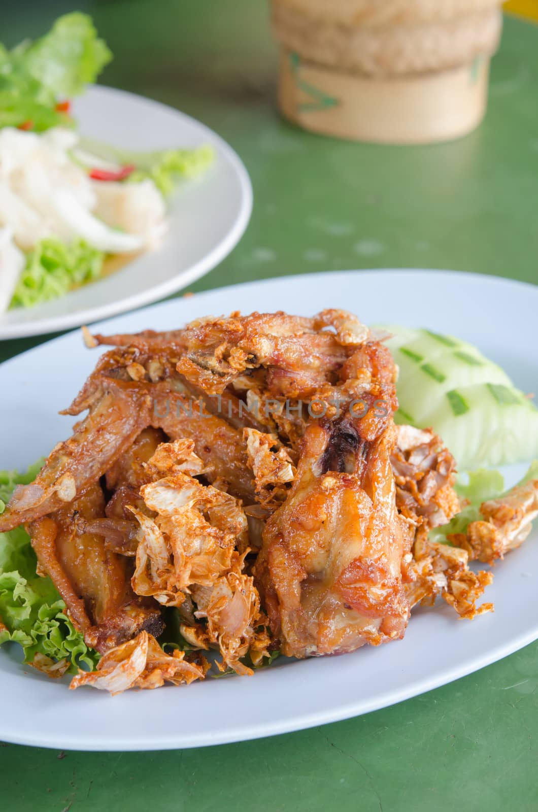 fried chicken served with fresh cucumber and lettuce  on dish