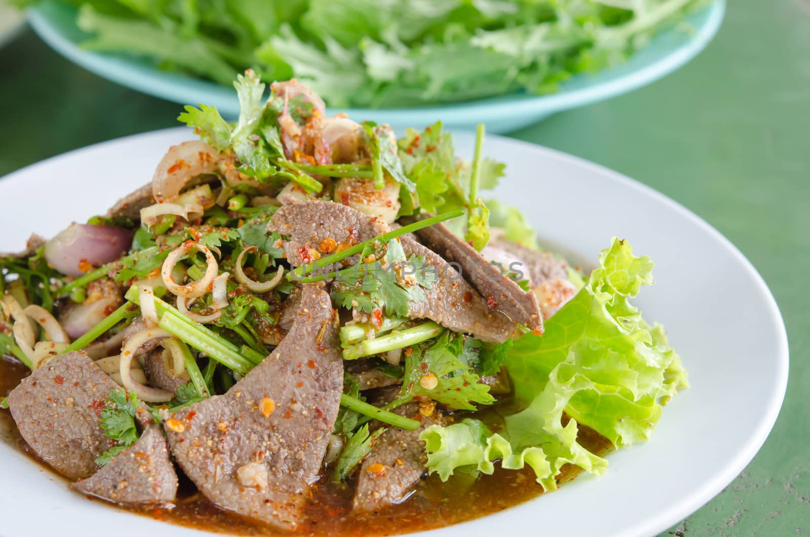close up spicy sliced liver salad with fresh vegetable on dish , asian spicy food