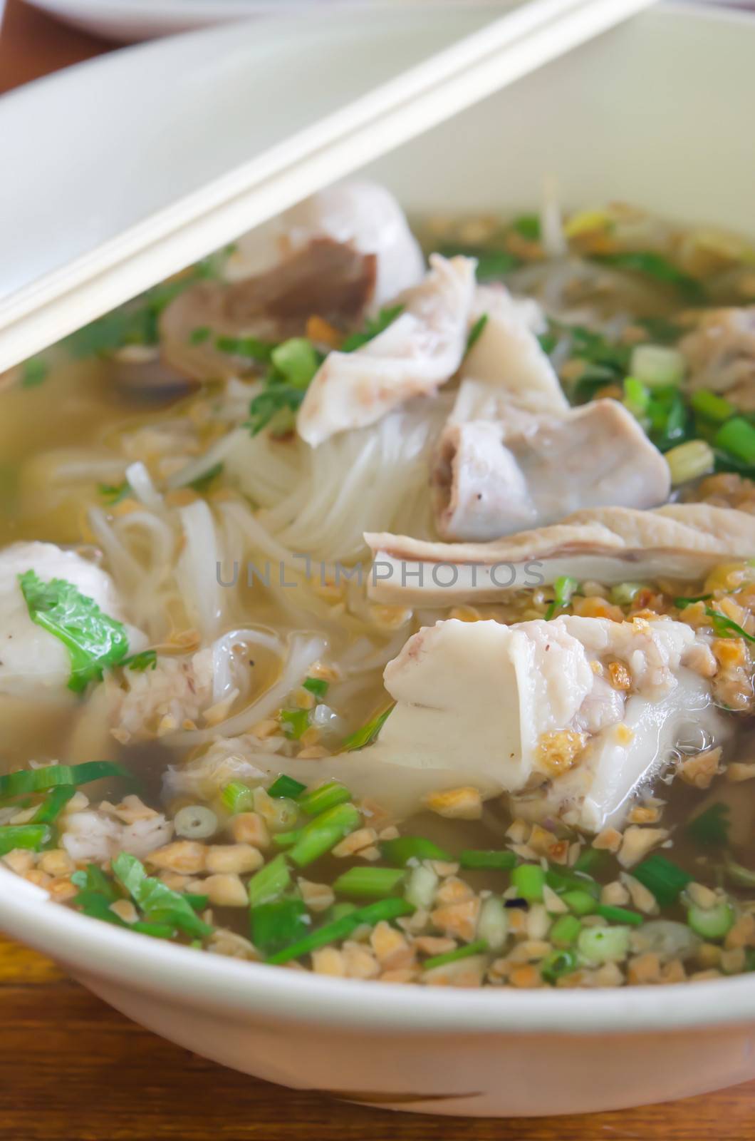  rice noodle soup with meat and vegetable with chopsticks