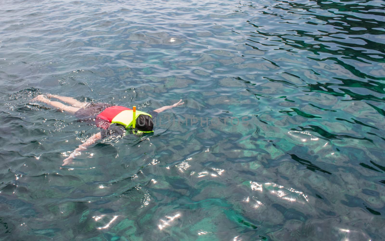 A man snorkeling in crystal turquoise sea water