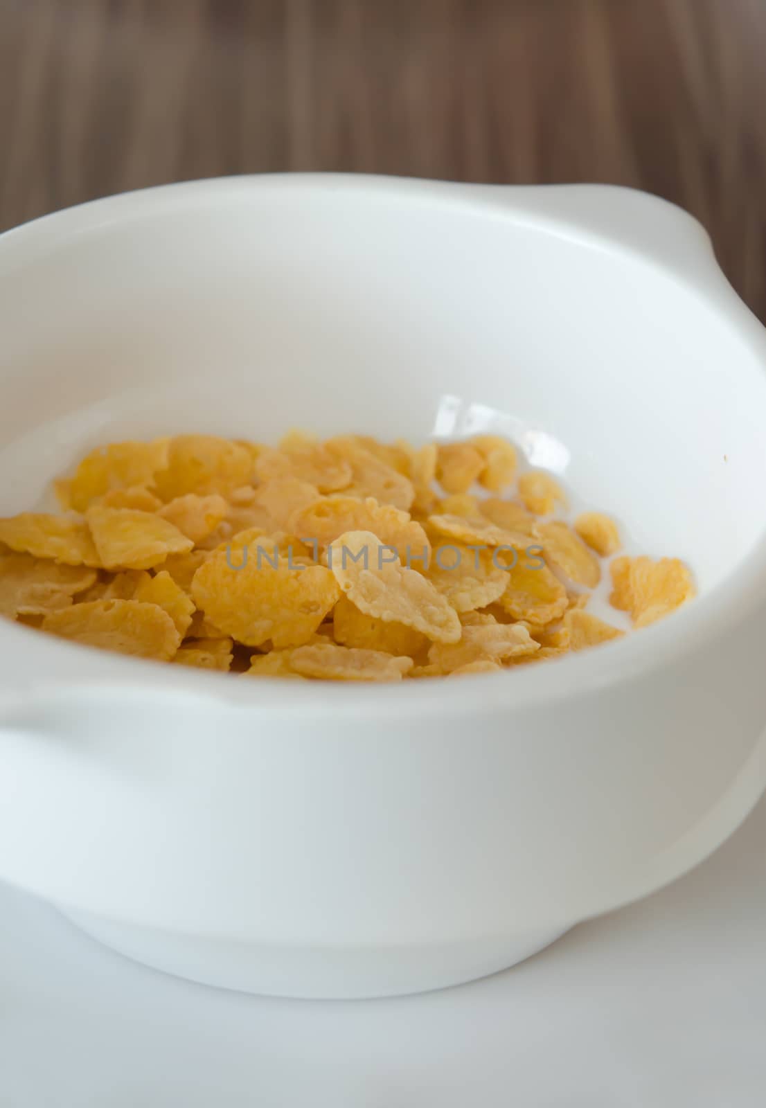 close up corn flake with fresh  milk in white bowl
