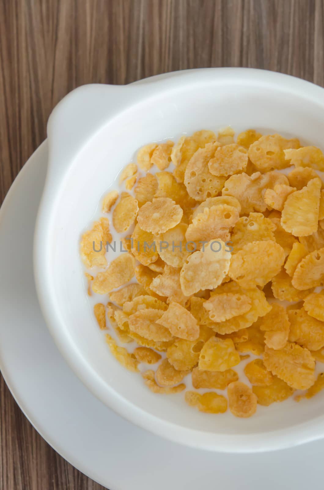 top view corn flake cereal with fresh  milk in white bowl