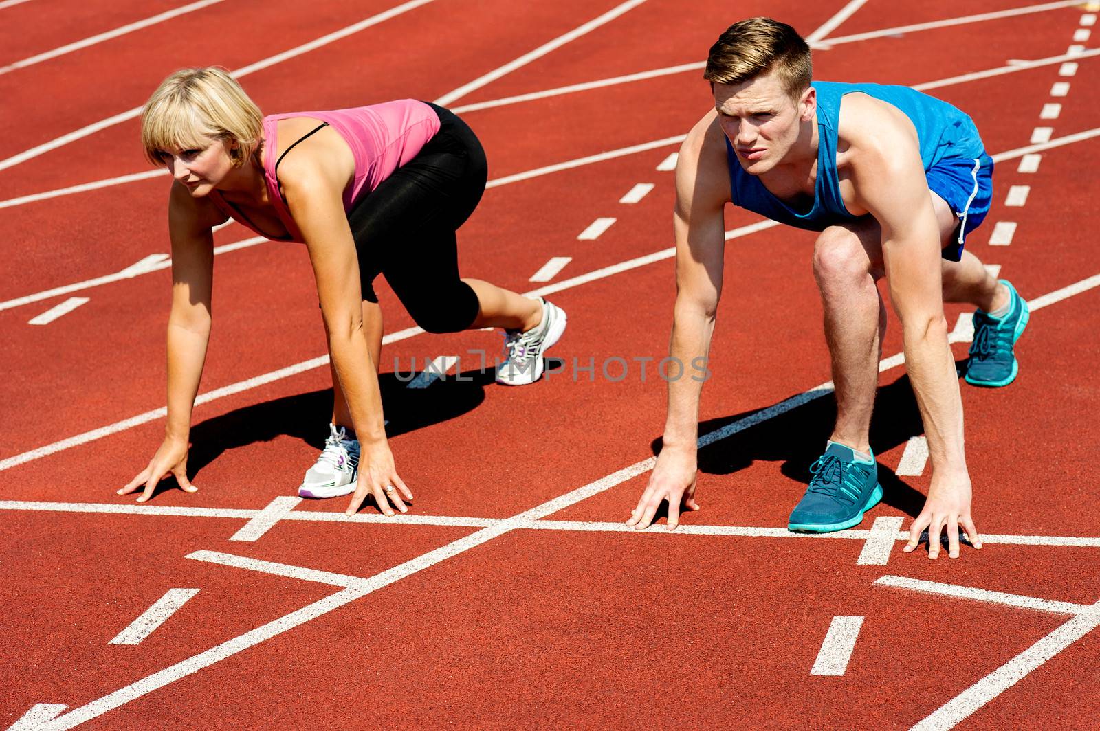 Athletes at starting line on race track by stockyimages
