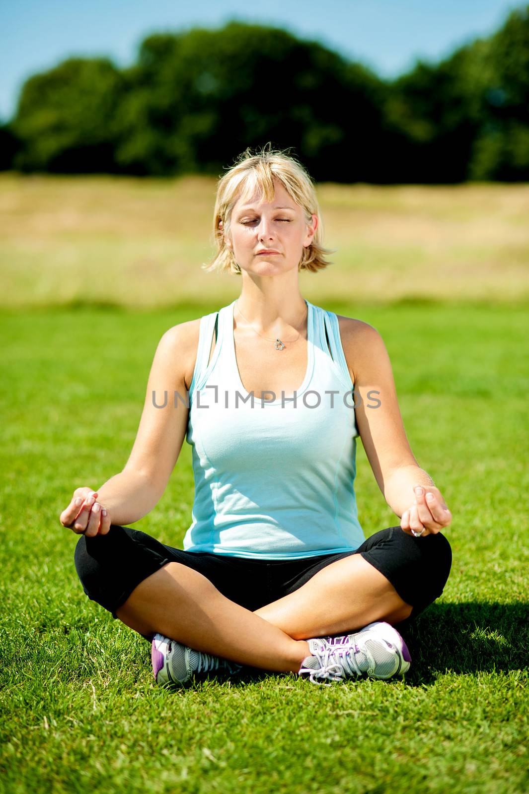 Middle aged woman practicing meditation outdoors