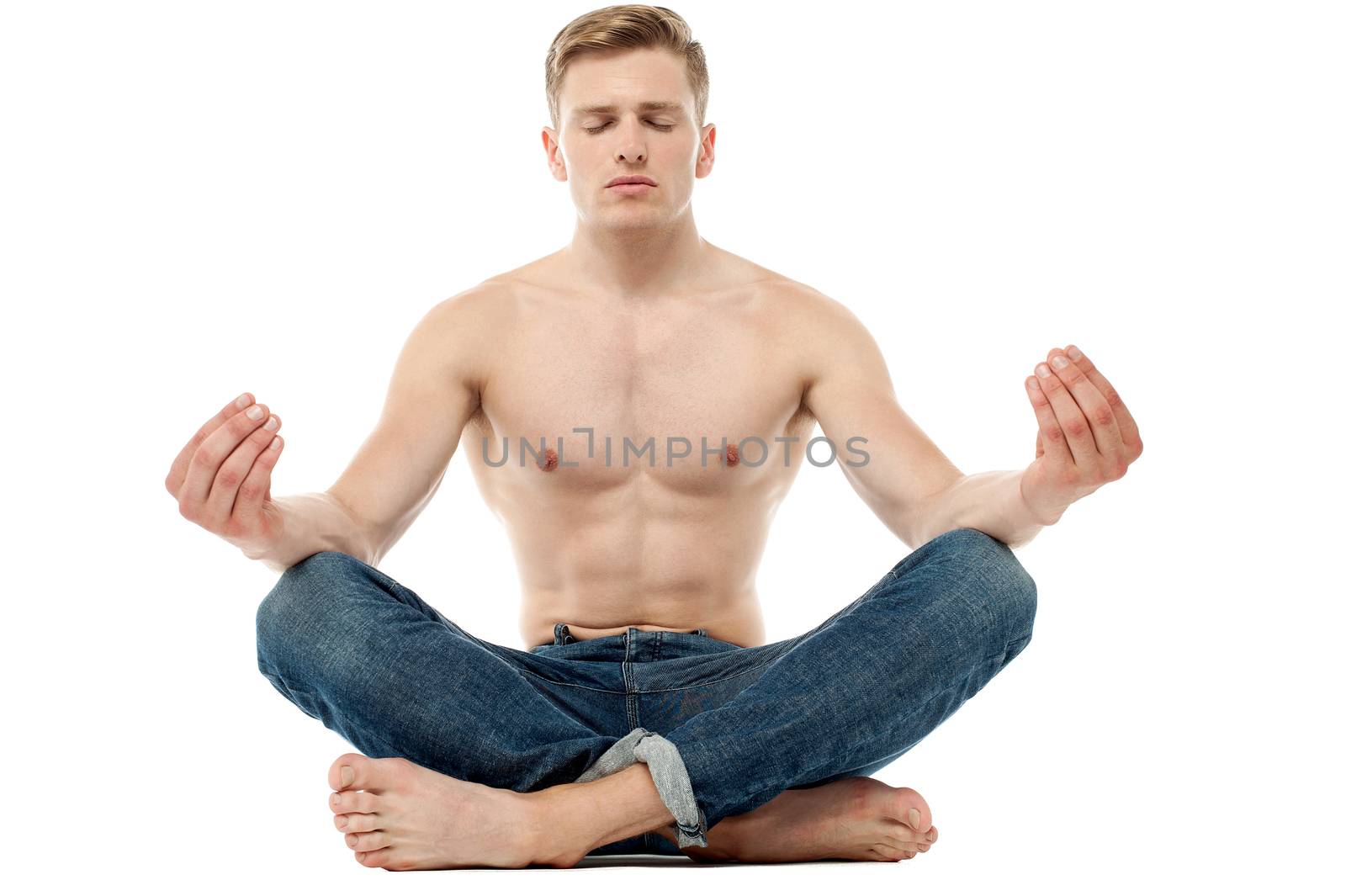 Shirtless young man doing meditation by stockyimages