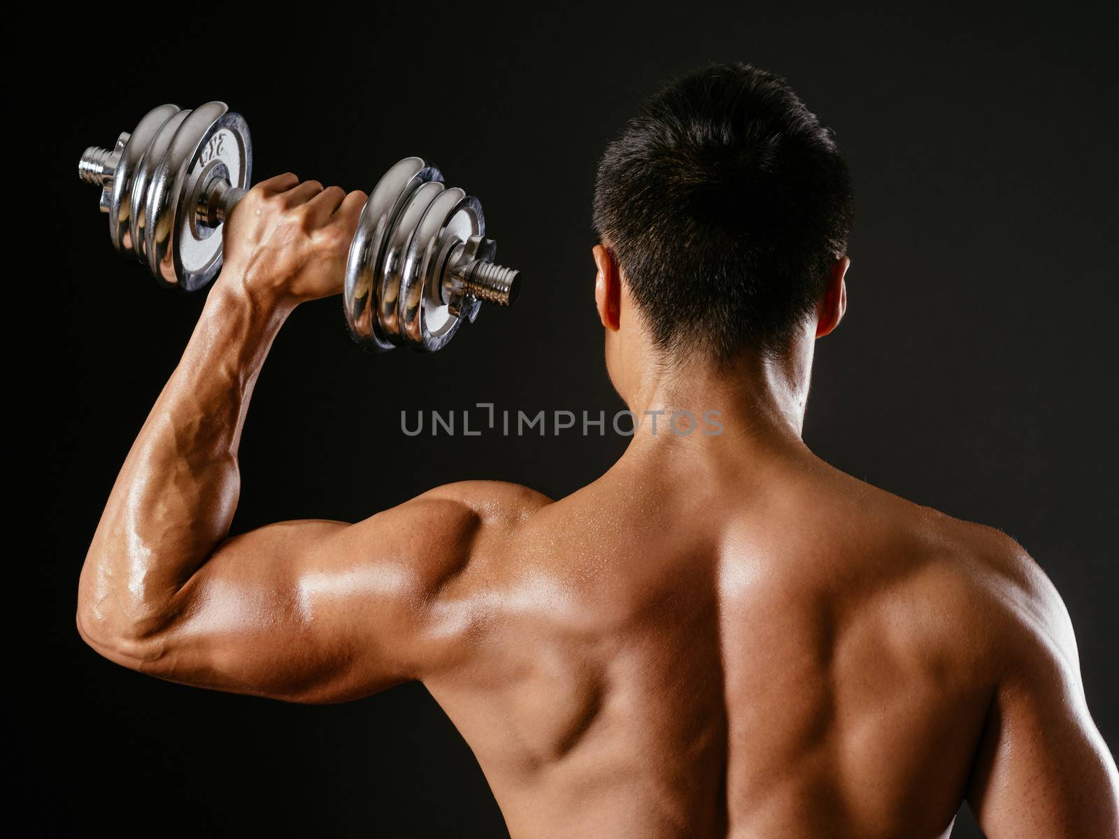 Asian male doing single shoulder press by sumners